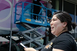 Angelina Villalobos outside with man lift in background.